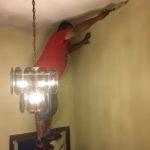 painter stands on door to paint ceiling funny